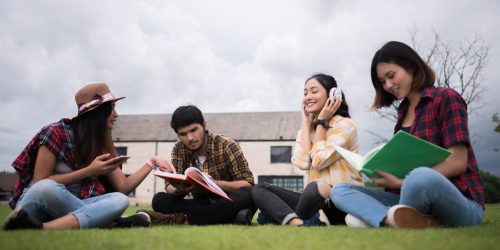 Group of student sitting at park after class. Enjoy talking toge